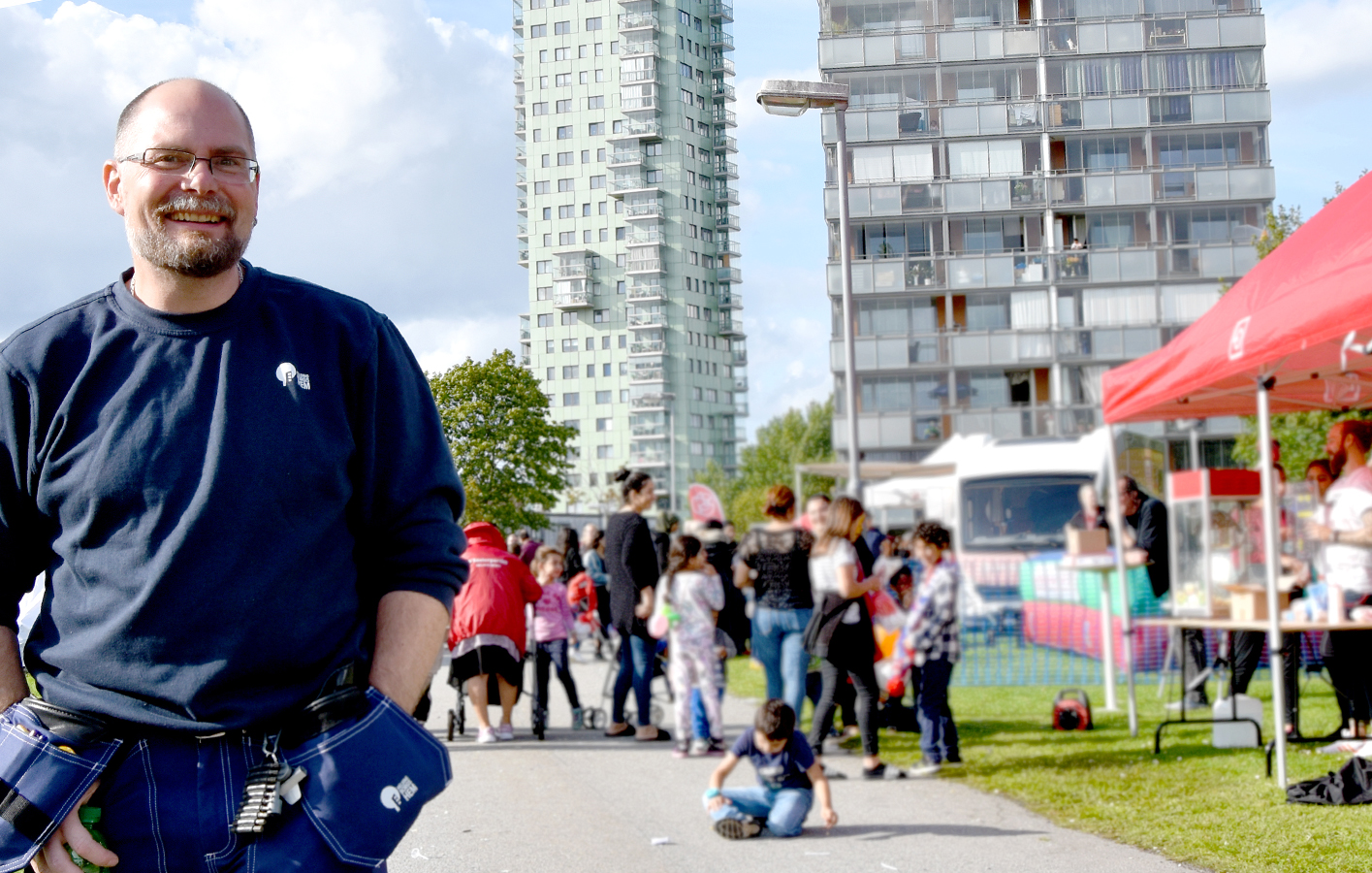 Kvartersansvarig på en områdesdag med människor i bakgrunden