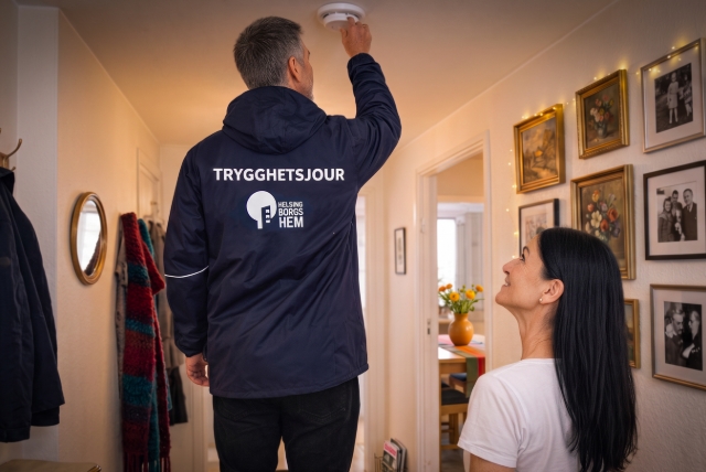 Man från Trygghetsjouren testar brandvarnare hemma hos hyresgäst.